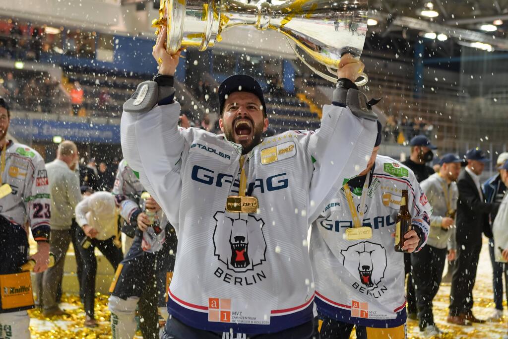 Da ist das Ding: Eisbären-Torwart Mathias Niederberger mit dem DEL-Pokal.